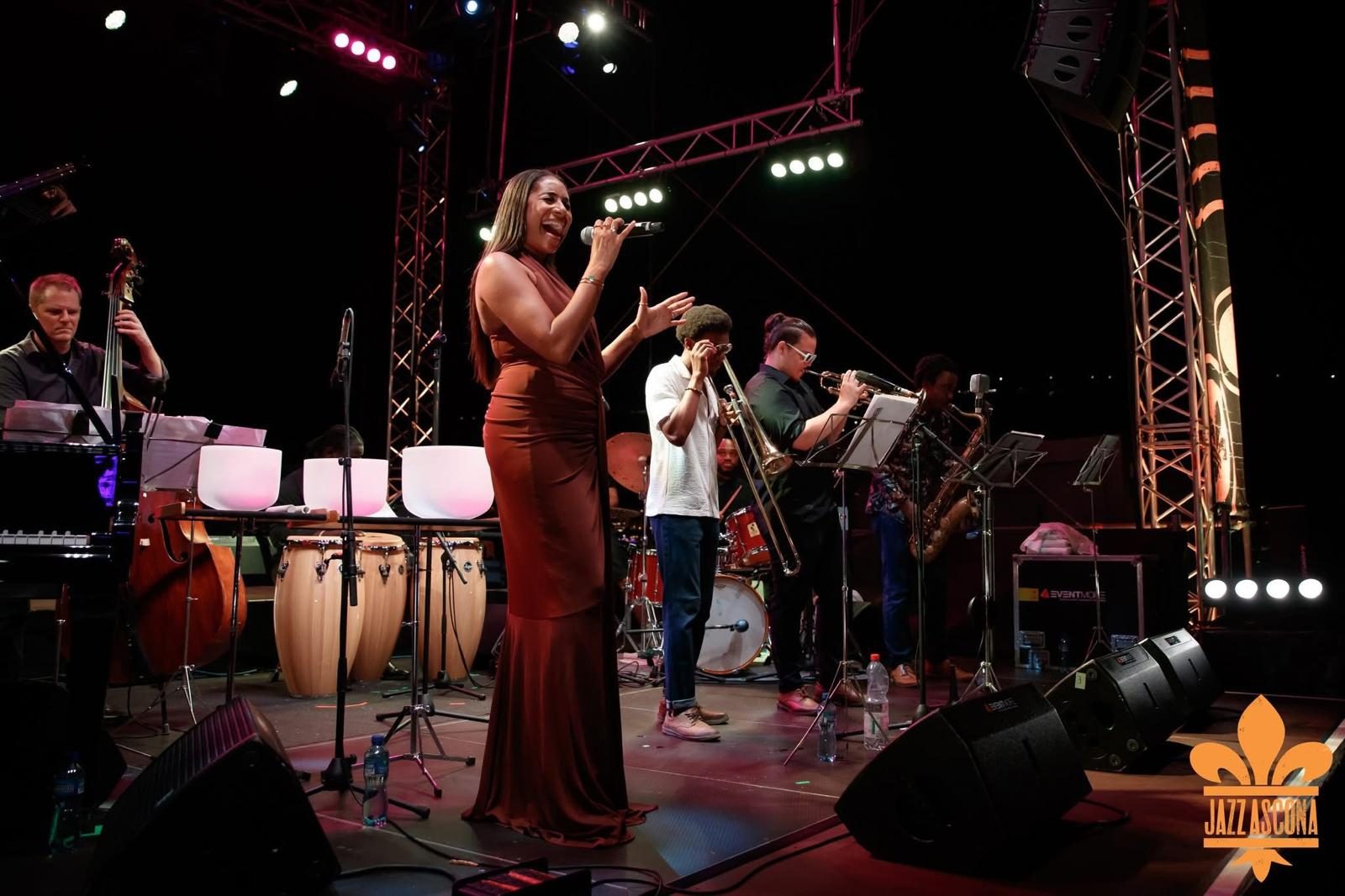 Vocalist in a copper gown singing with a horn section at Jazz Ascona